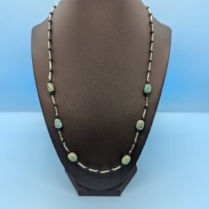 a turquoise necklace on a mannequin