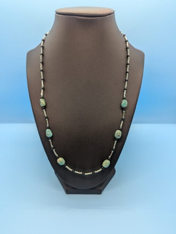 a turquoise necklace on a mannequin